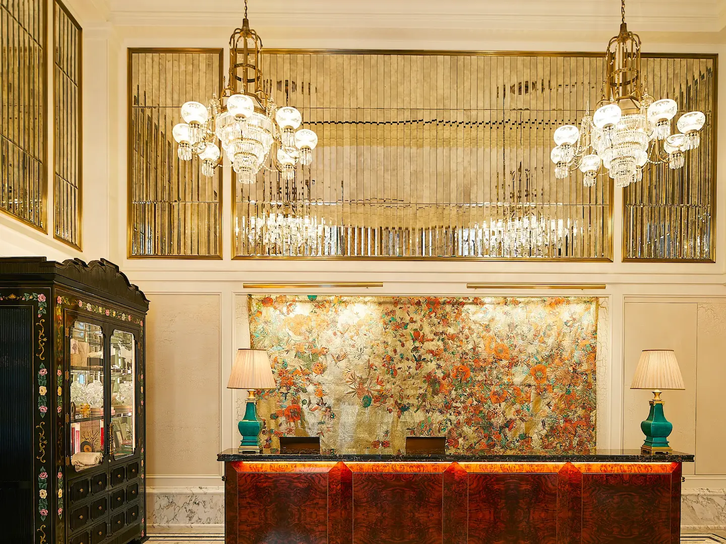 Two beautifully designed lamps on the table and two chandeliers light up the room.